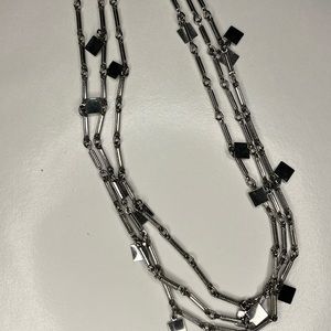 Silver 3 strand chain, metal bar with square charms. Hangs 27” long
